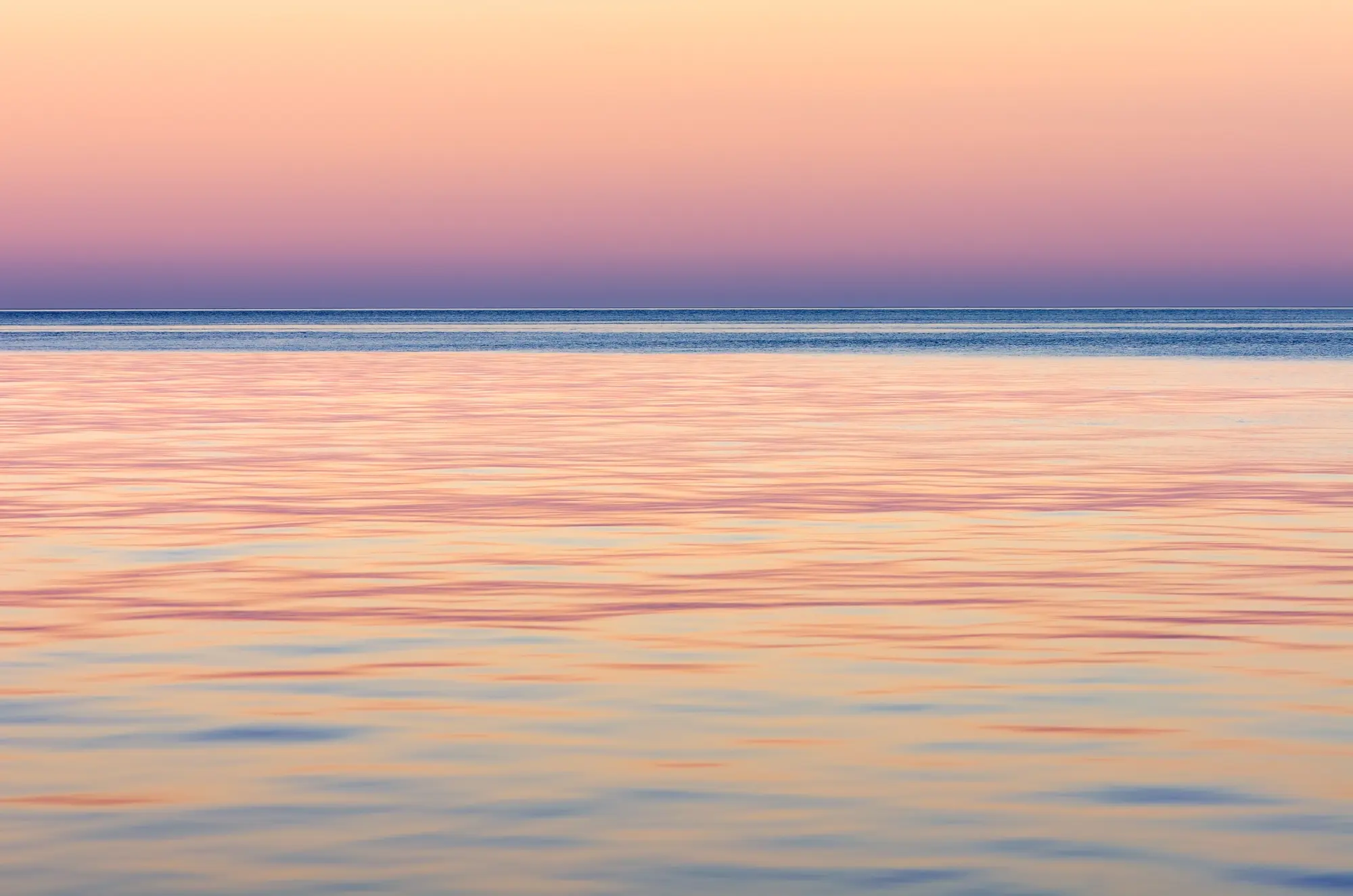 Orizzonte sul mare all'alba, una linea tra due distese