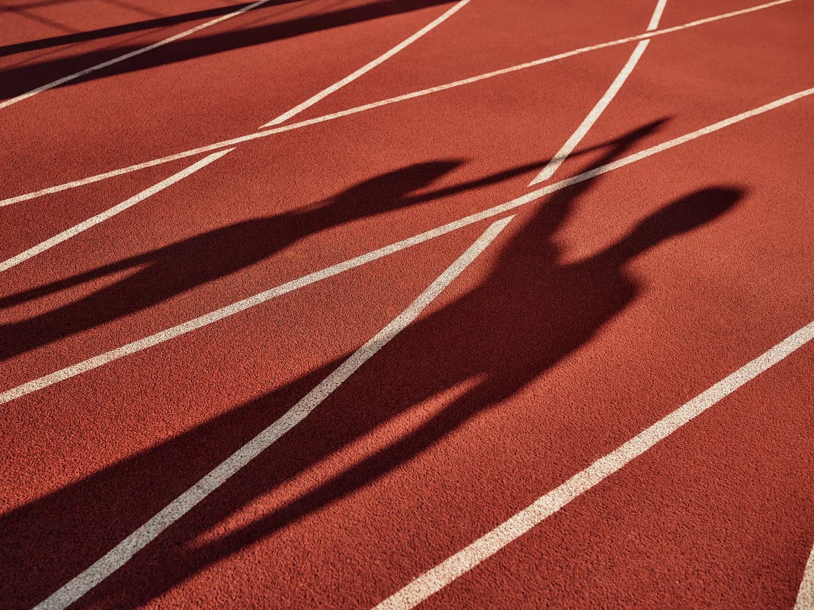 Ombre di atleti su una pista d’atletica